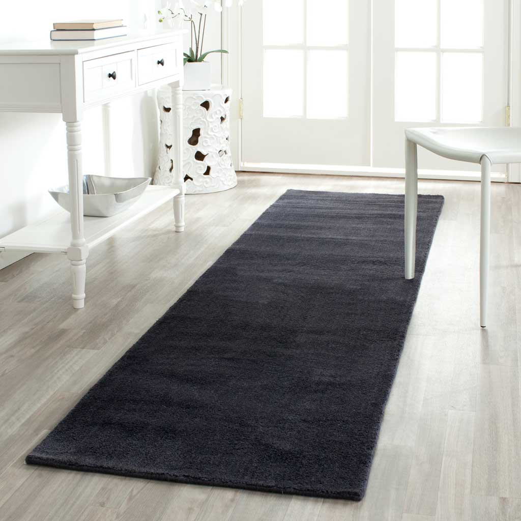 Black runner adds grounding contrast and plush texture to a light entryway.