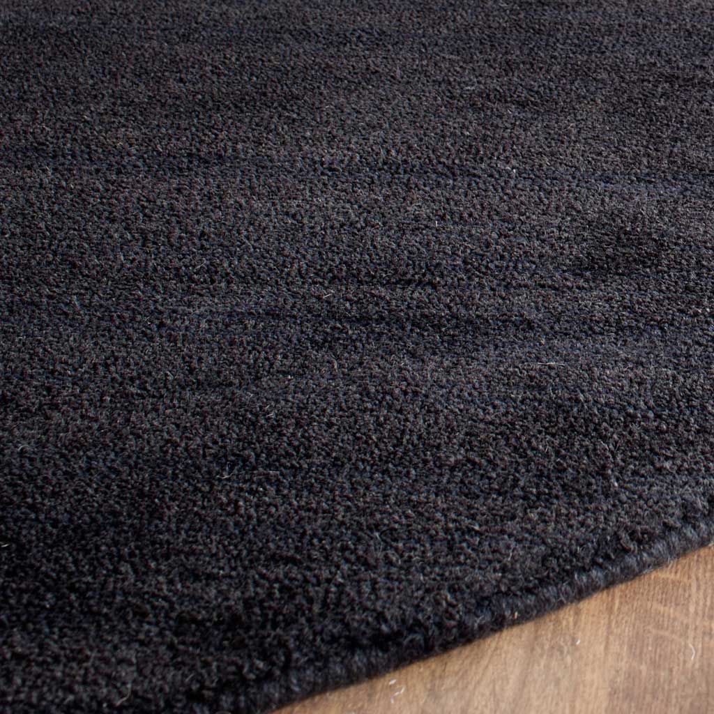 Dense black fibers give the plush pile rich texture along its curved edge