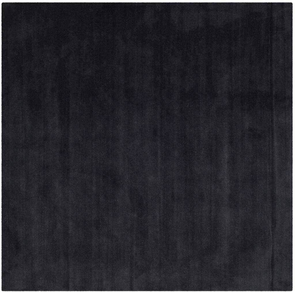 Square black rug reveals soft tonal streaks across its understated surface