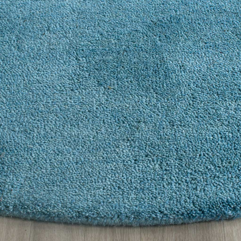 Hand-tufted blue pile adds cushioned texture beside the rug's clean curved edge