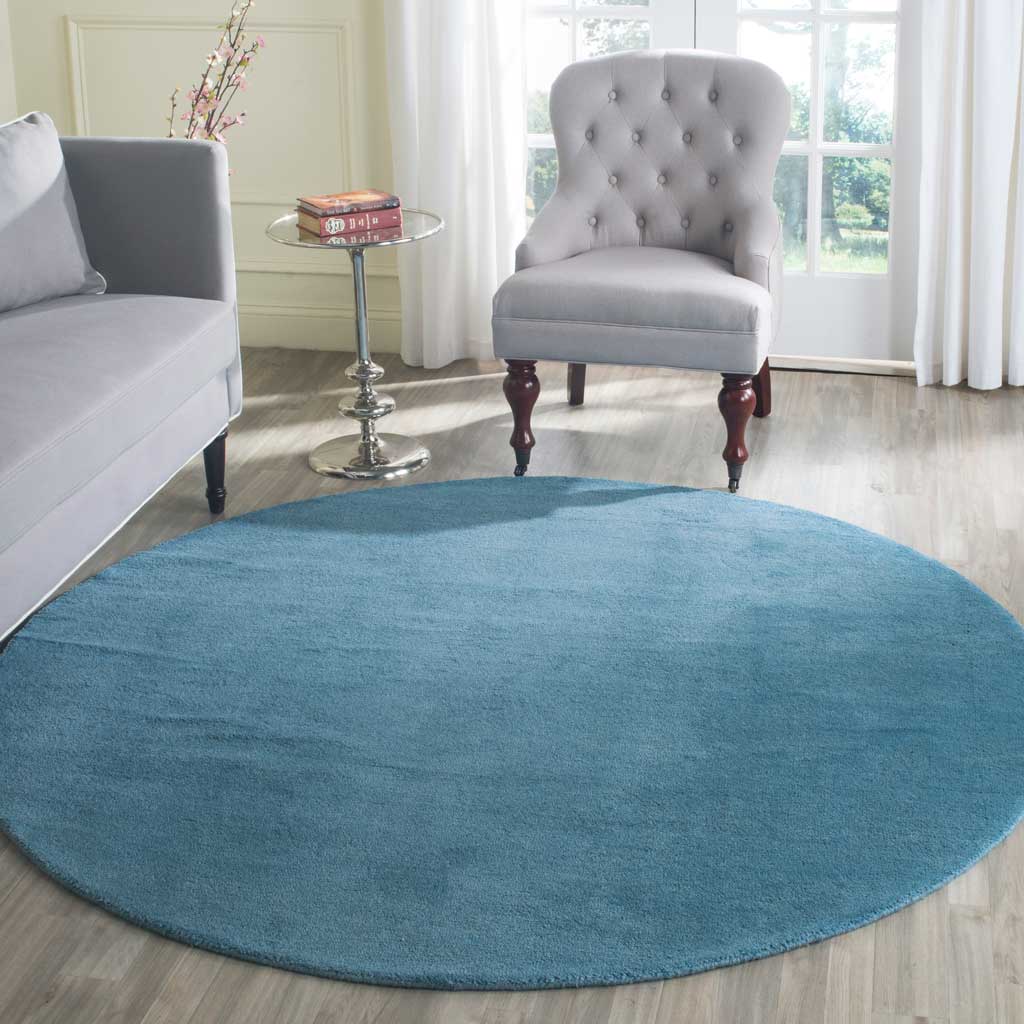 Calming blue round rug softens the seating area with a plush, tonal surface
