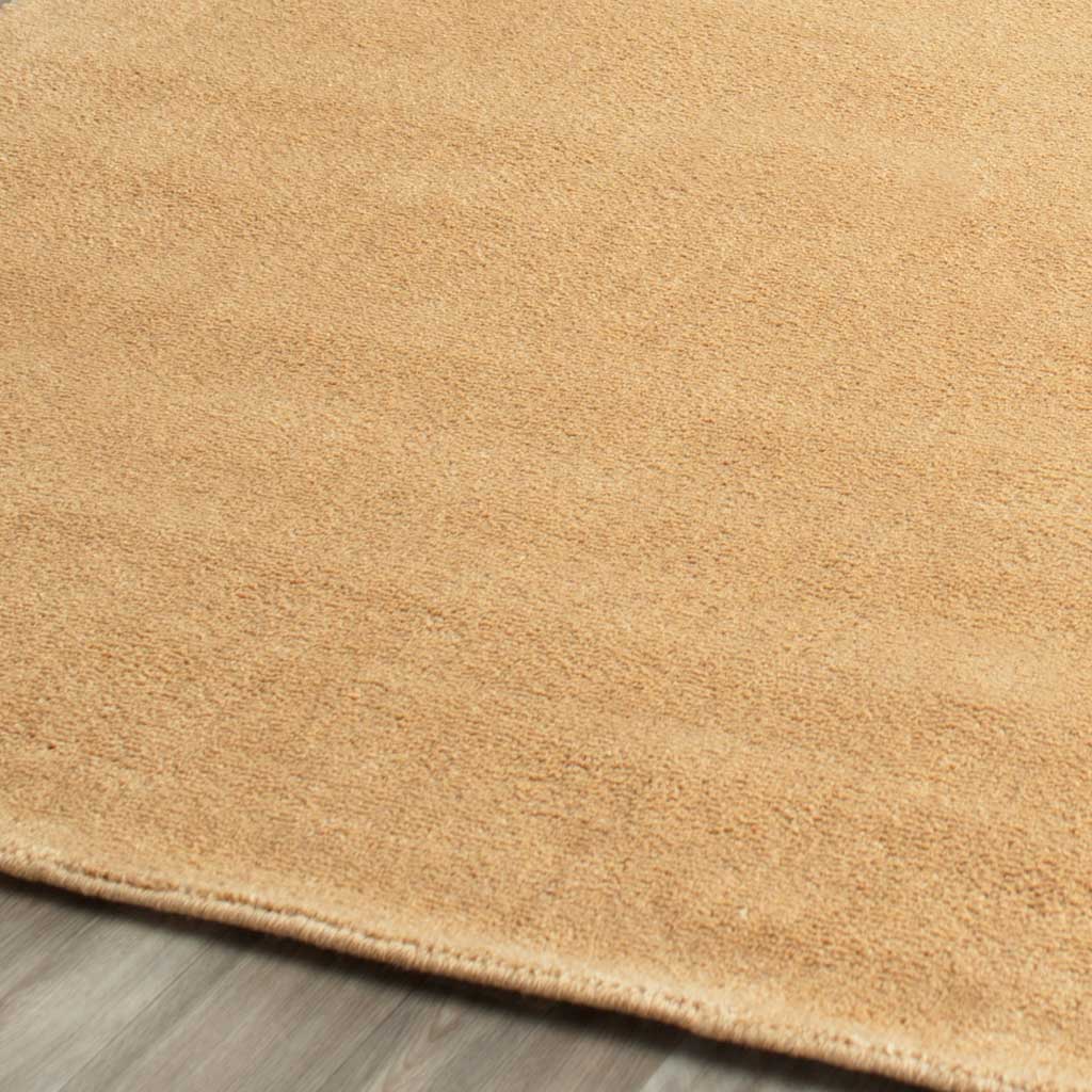 Warm beige fibers meet a slim finished edge for a soft, understated rug texture