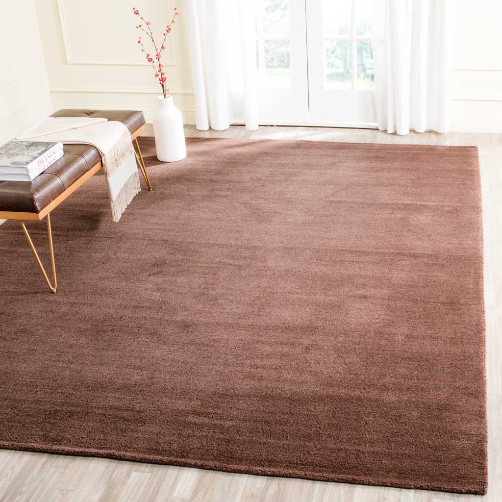 Generous brown rug adds rich texture to an airy room with understated tonal variation