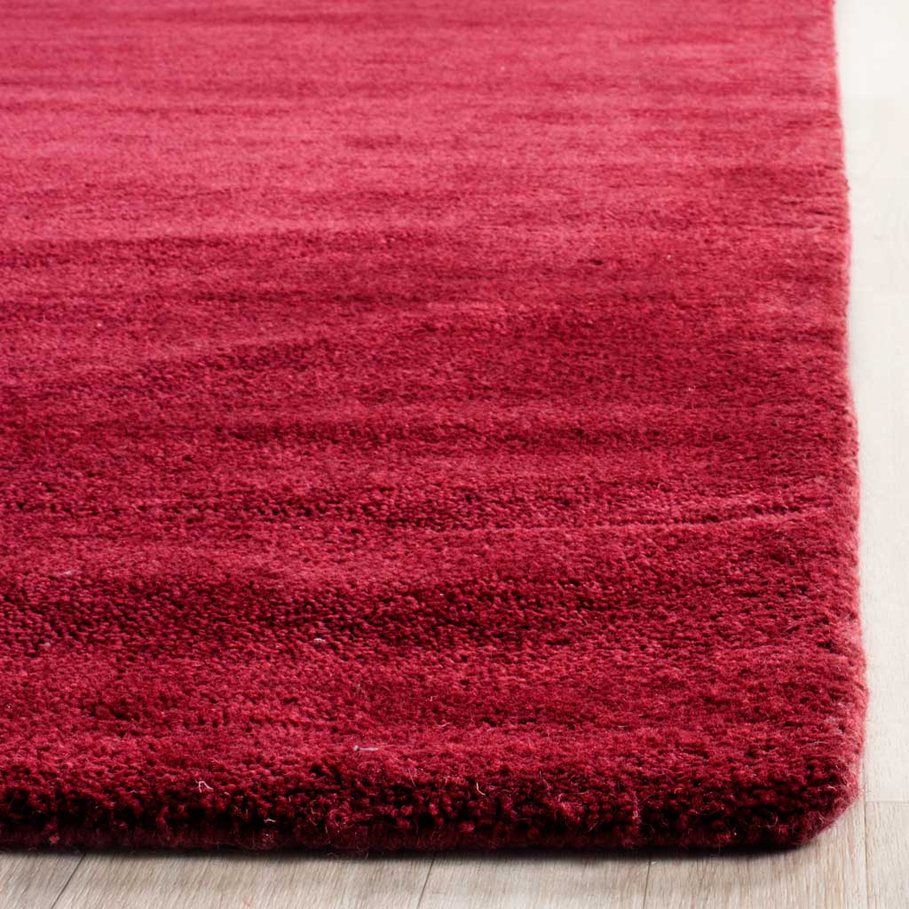 Plush red pile meets a thick, neatly finished corner with layered crimson tones