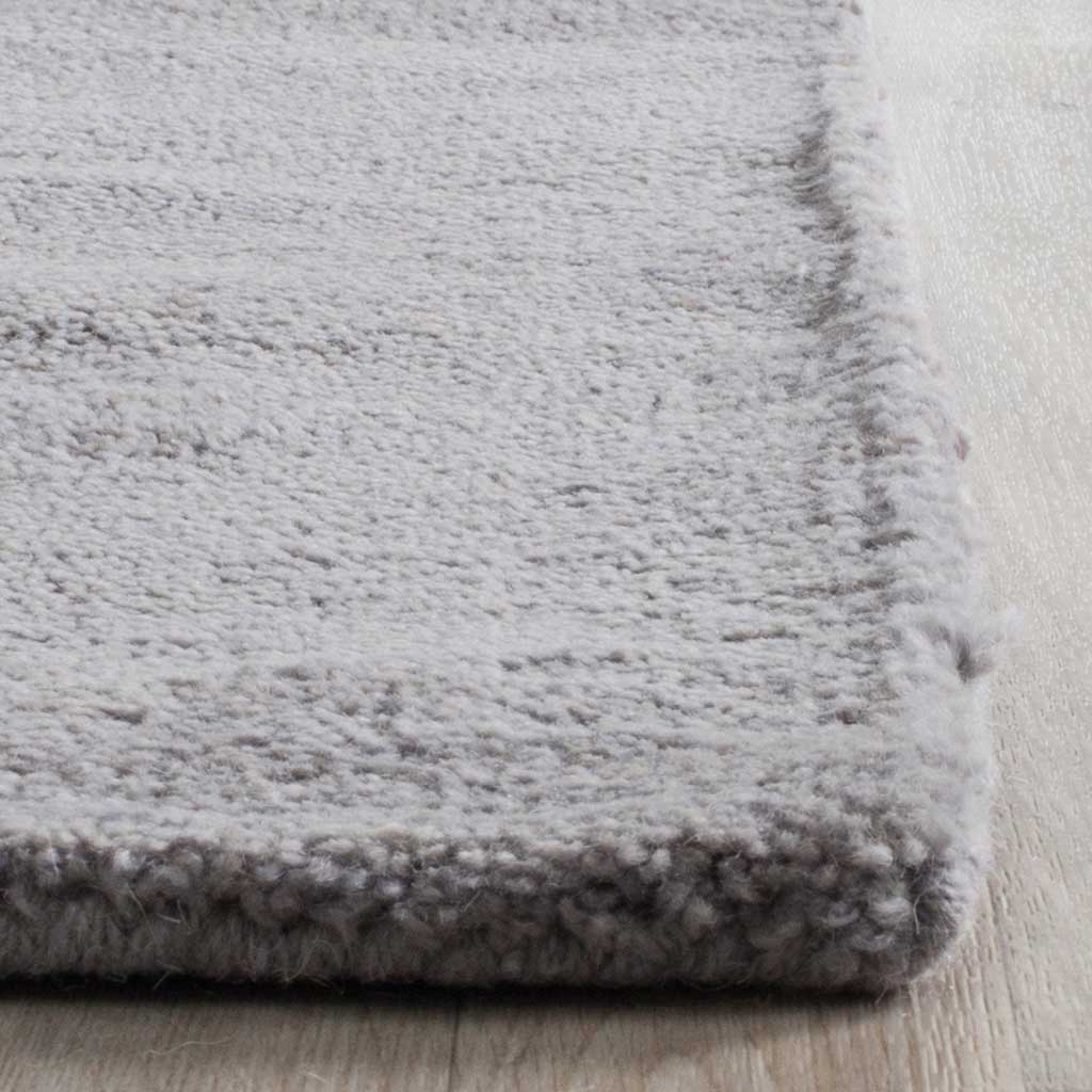 Thick gray pile and a tightly finished edge offer a plush, textured touch.