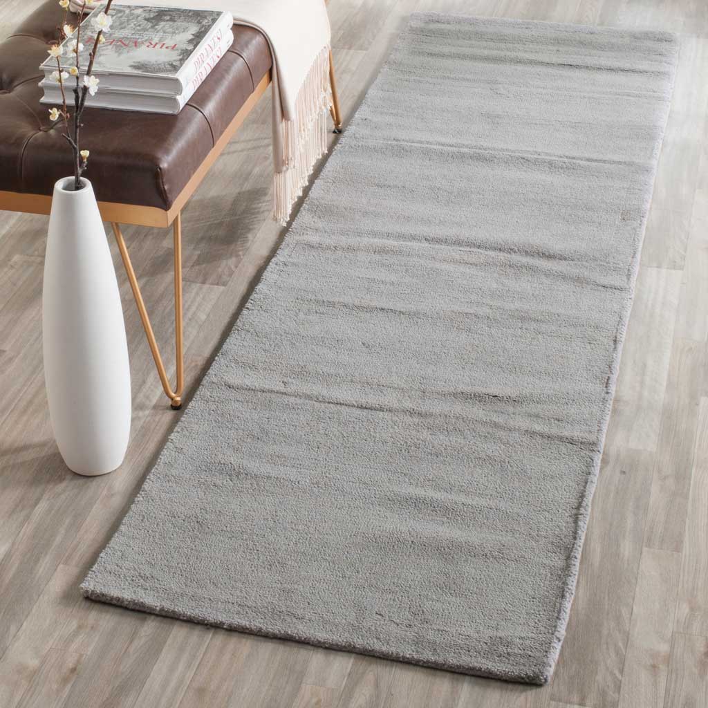 Tonal gray runner lends soft texture and a calming foundation beside a leather bench.