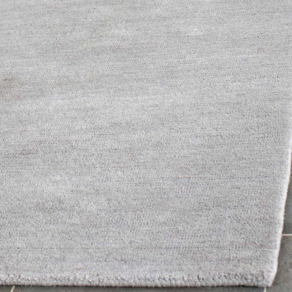 Soft gray pile meets a neatly finished corner, showing subtle shifts in color