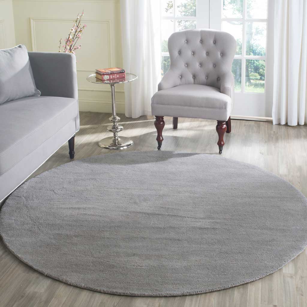 Understated gray round rug adds softness and subtle color to a bright sitting area