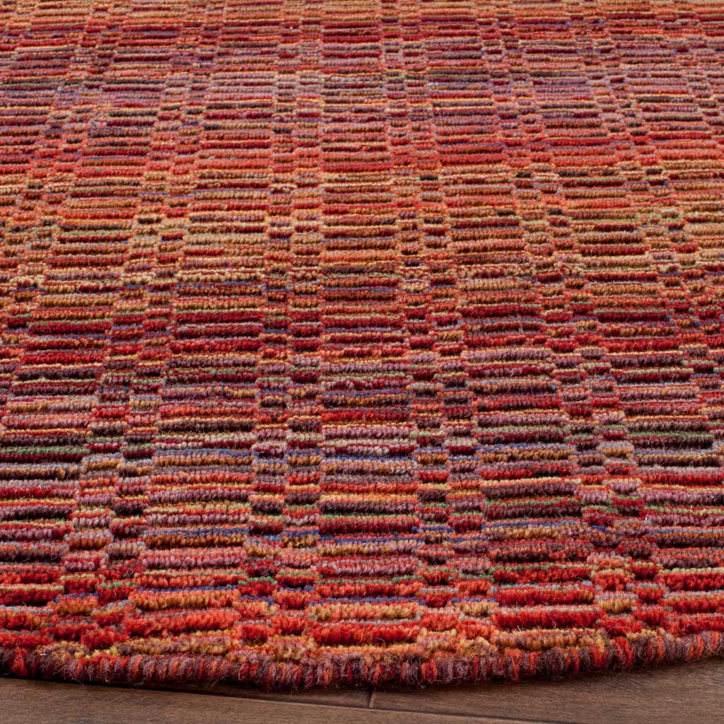 Textured wool reveals fine stripes in red, orange and plum along a neatly finished edge.