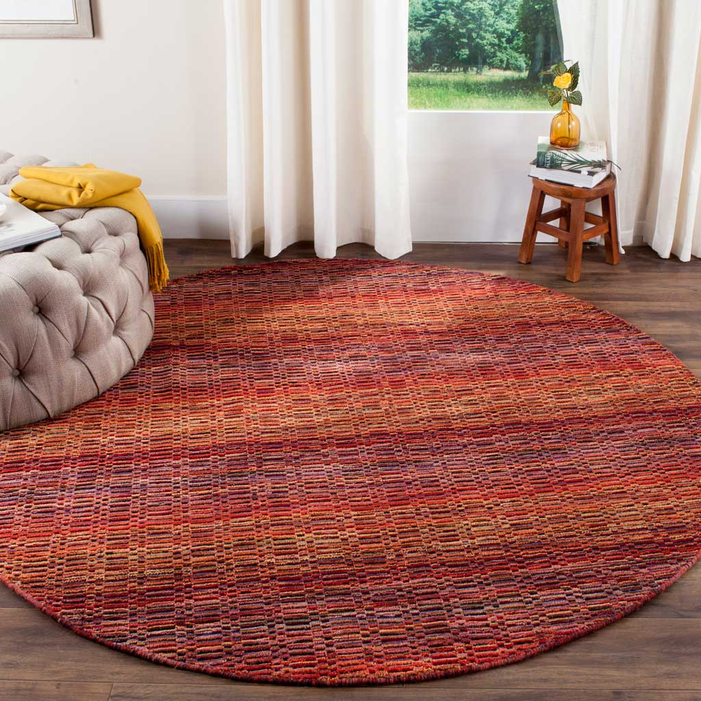 A round wool rug with richly textured red and multicolor stripes complements warm wood floors.