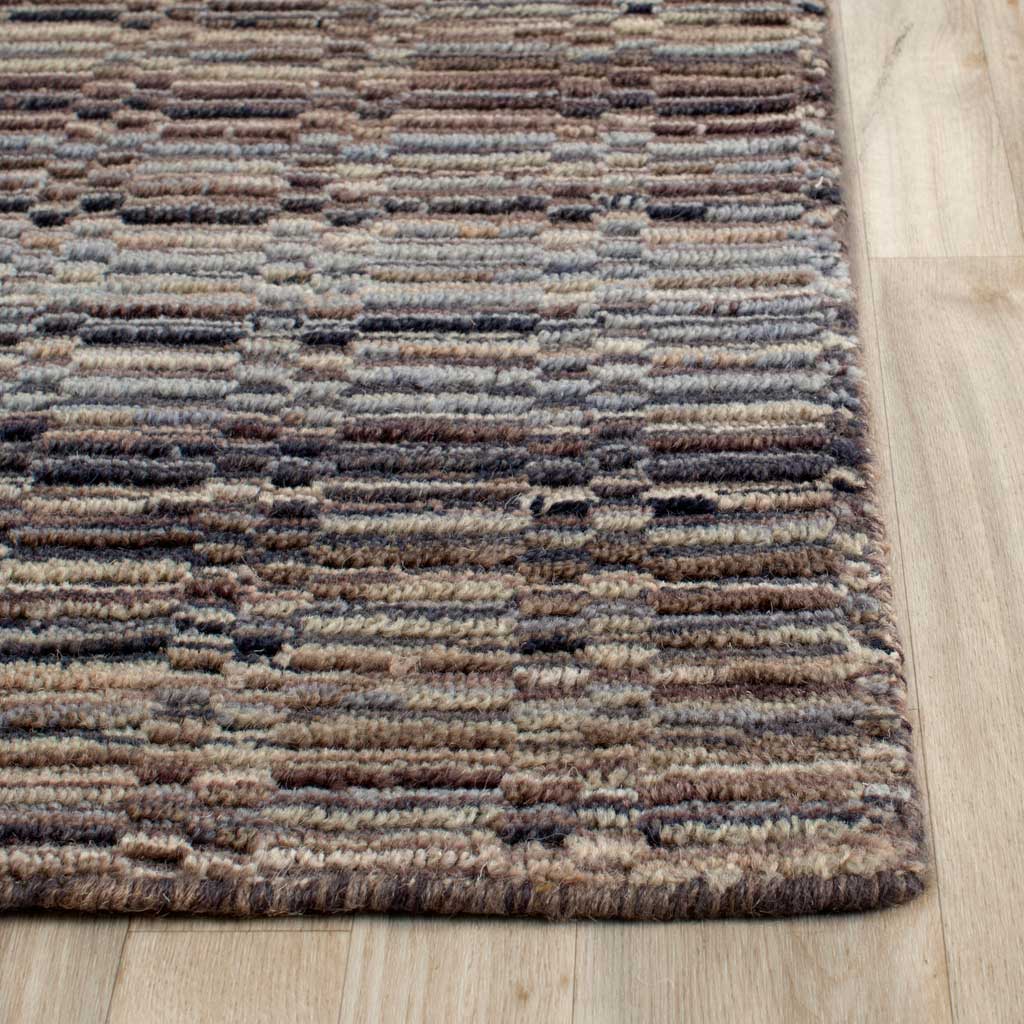 A textured wool weave blends taupe, beige, and dark blue tones along the rug's edge