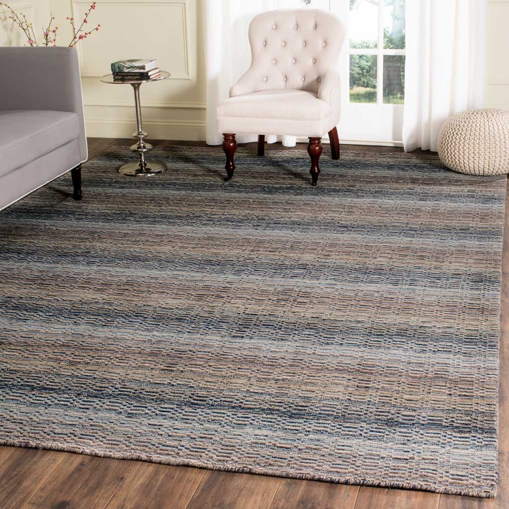 Subtle beige and blue stripes add warmth and texture beneath pale upholstered furniture