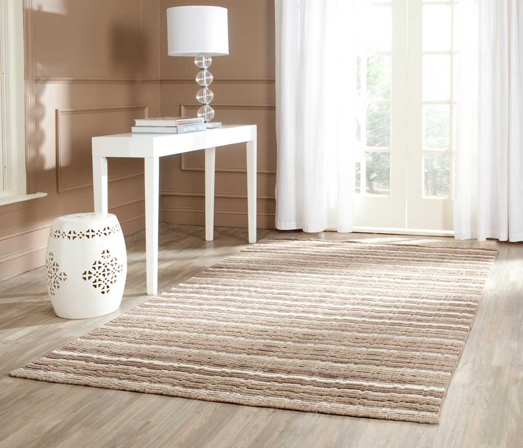 Earthy brown and cream stripes bring inviting texture to this hand-loomed wool area rug