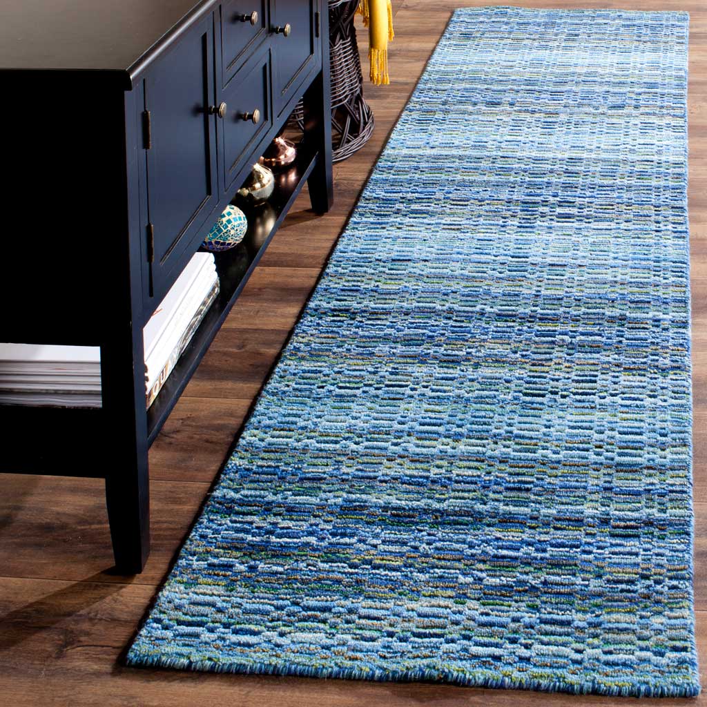 A low-profile runner brings vivid blue and teal texture to a warm wood floor
