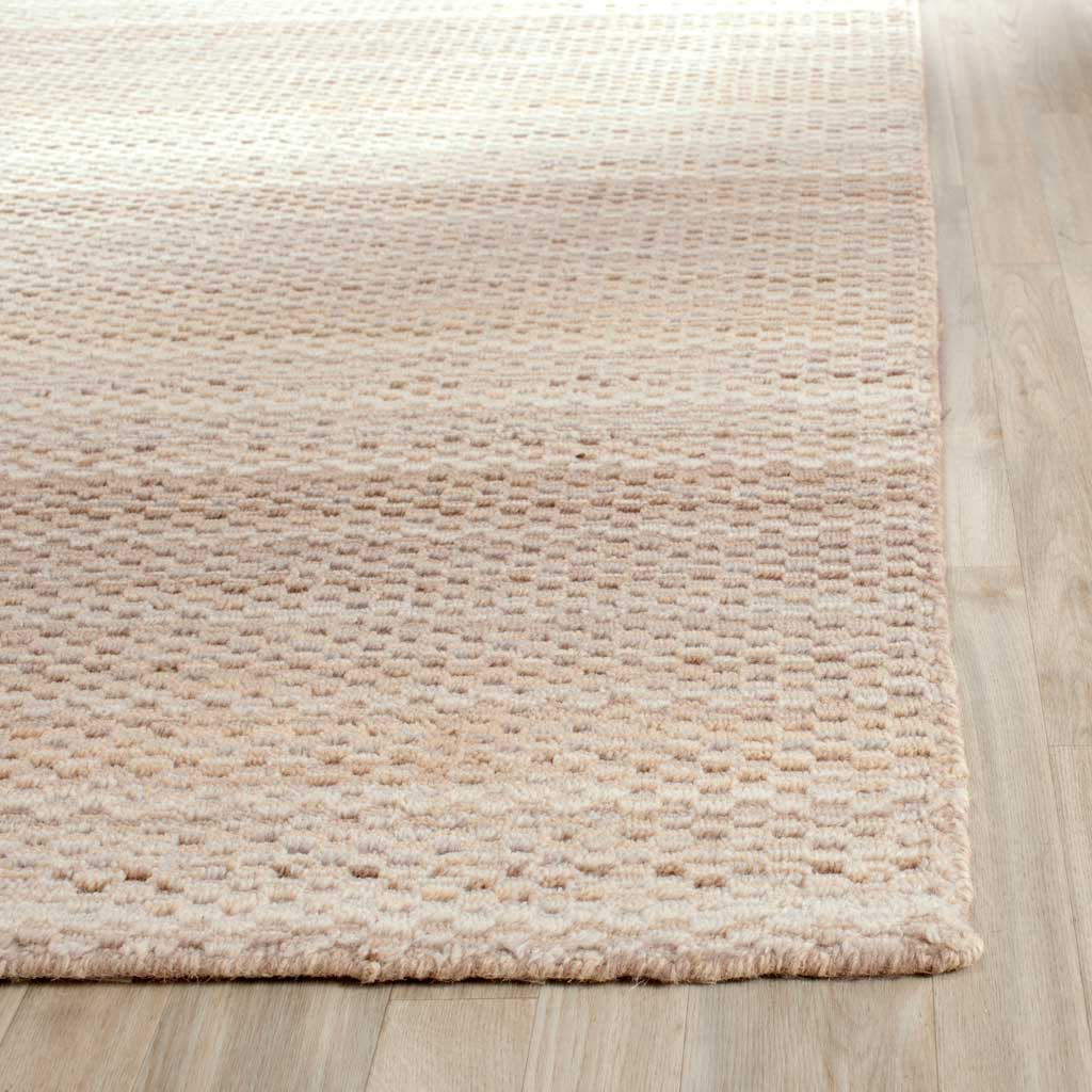 Soft, raised wool texture and a tidy edge bring inviting detail to the beige rug