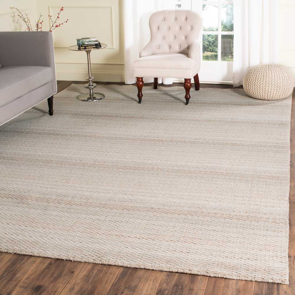 Beige wool rug layers gentle stripes and cozy texture beneath a living room seating area
