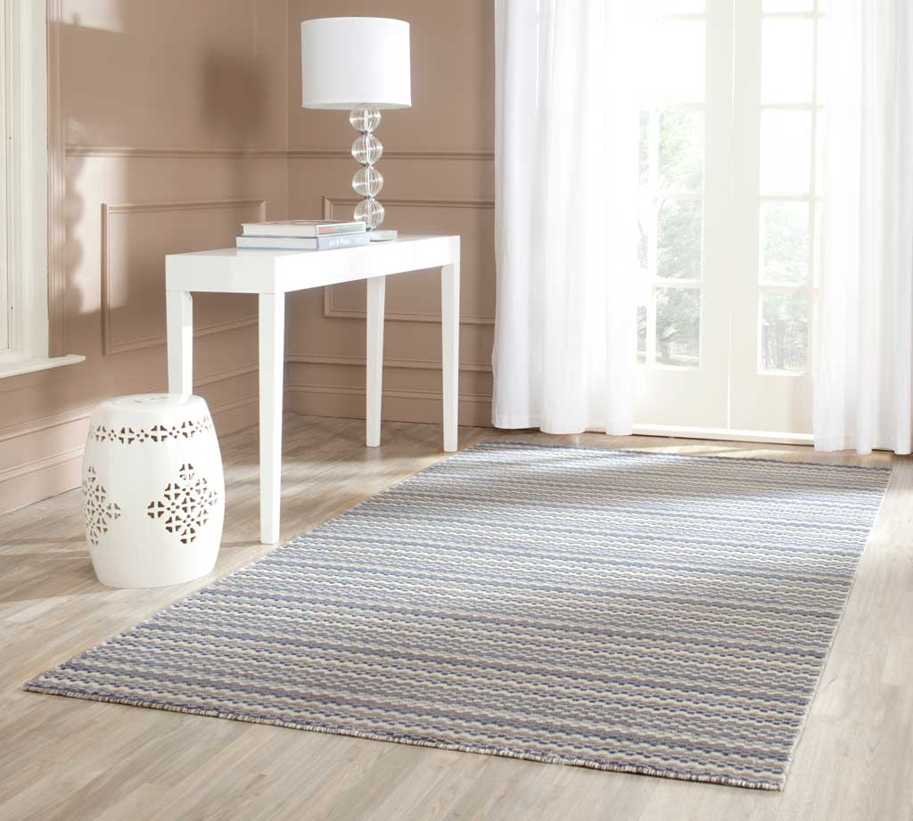 A striped wool rug adds soft beige and gray texture to a bright, airy living space