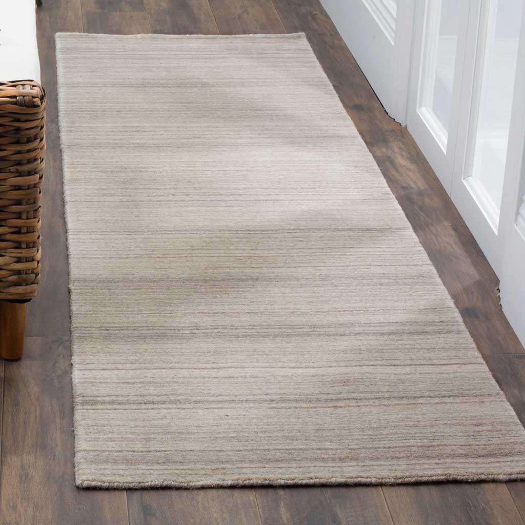 Subtly striped stone runner adds soft texture and understated warmth to a narrow hallway