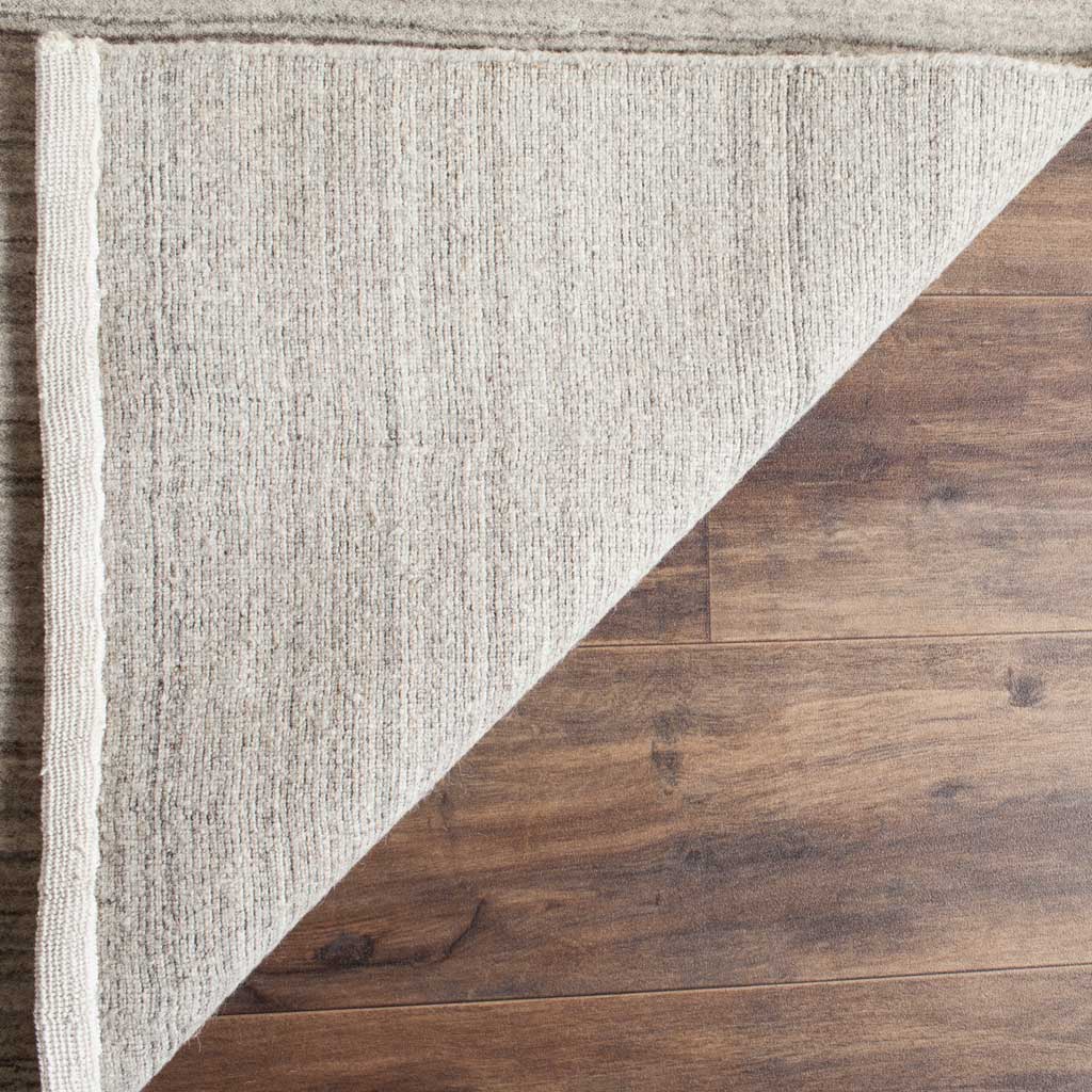 A folded corner reveals the rug's woven backing and neatly finished edge