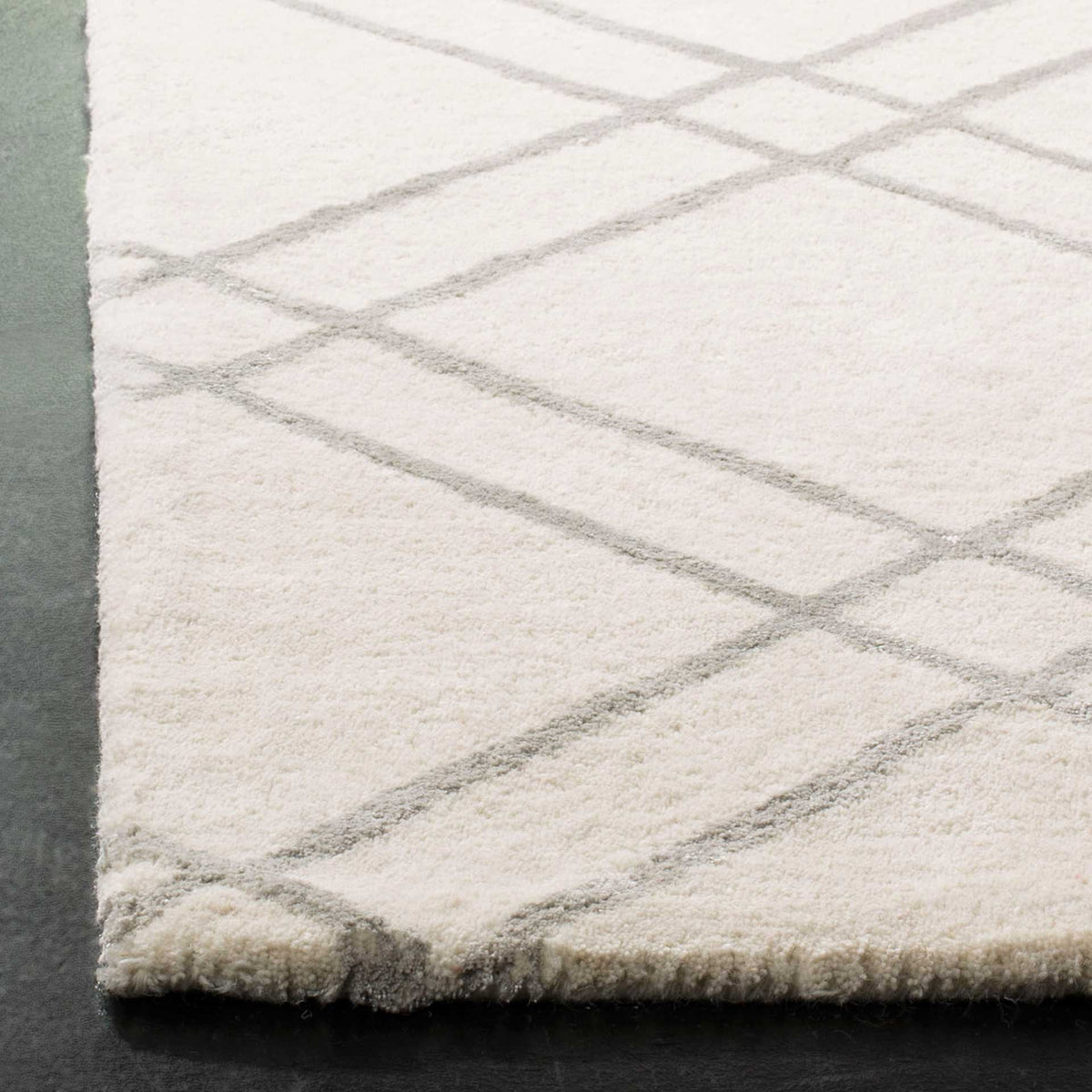 Soft ivory wool pile is traced with fine silver lines at a clean edge