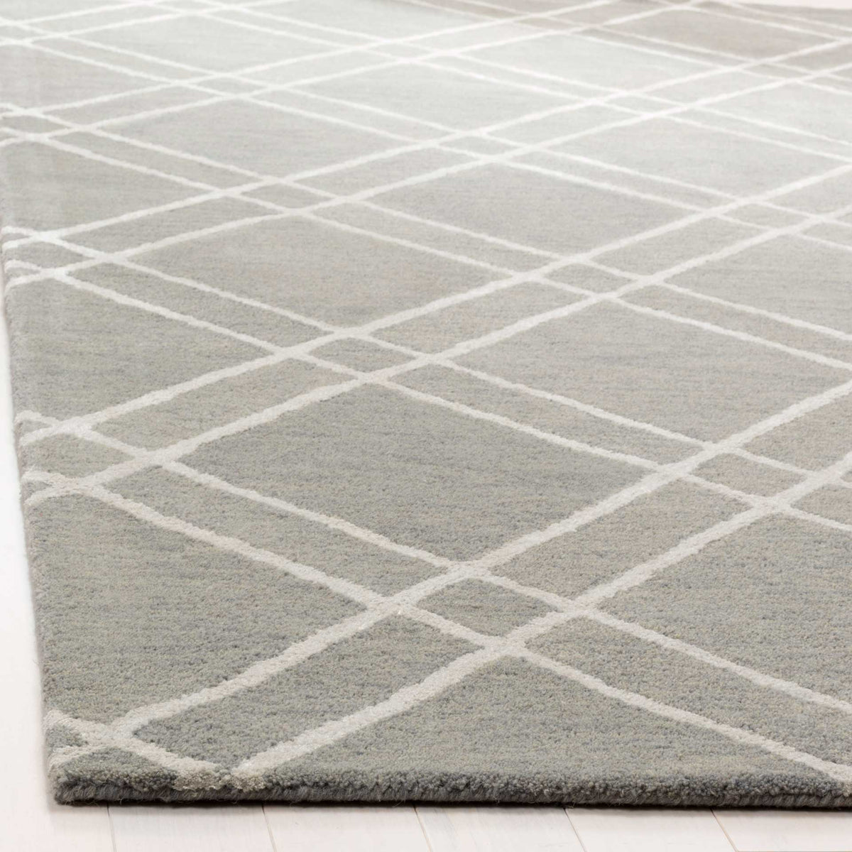 Dense gray wool pile and silver lines meet at a neatly finished edge