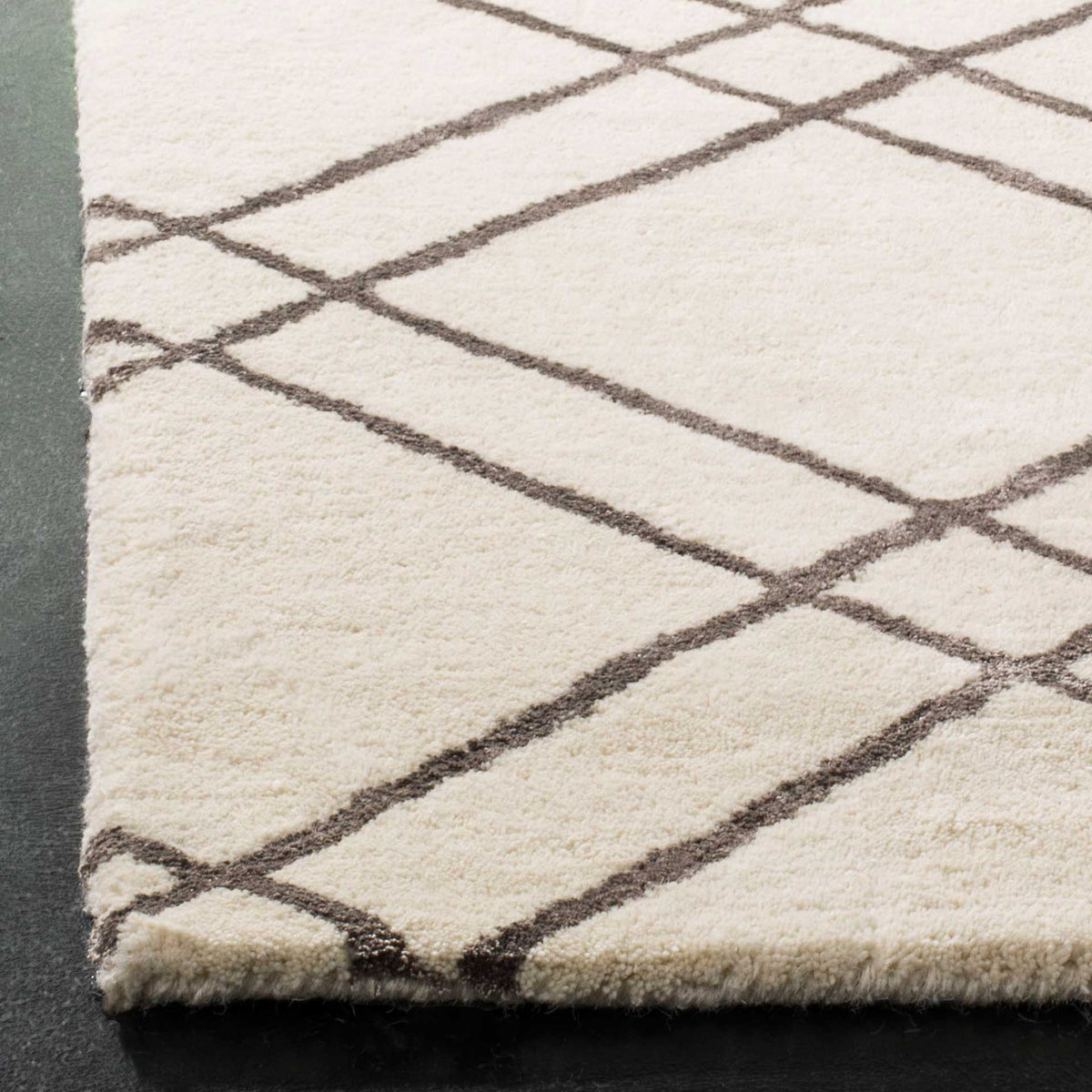 Plush ivory wool meets intersecting dark gray lines along a finished edge