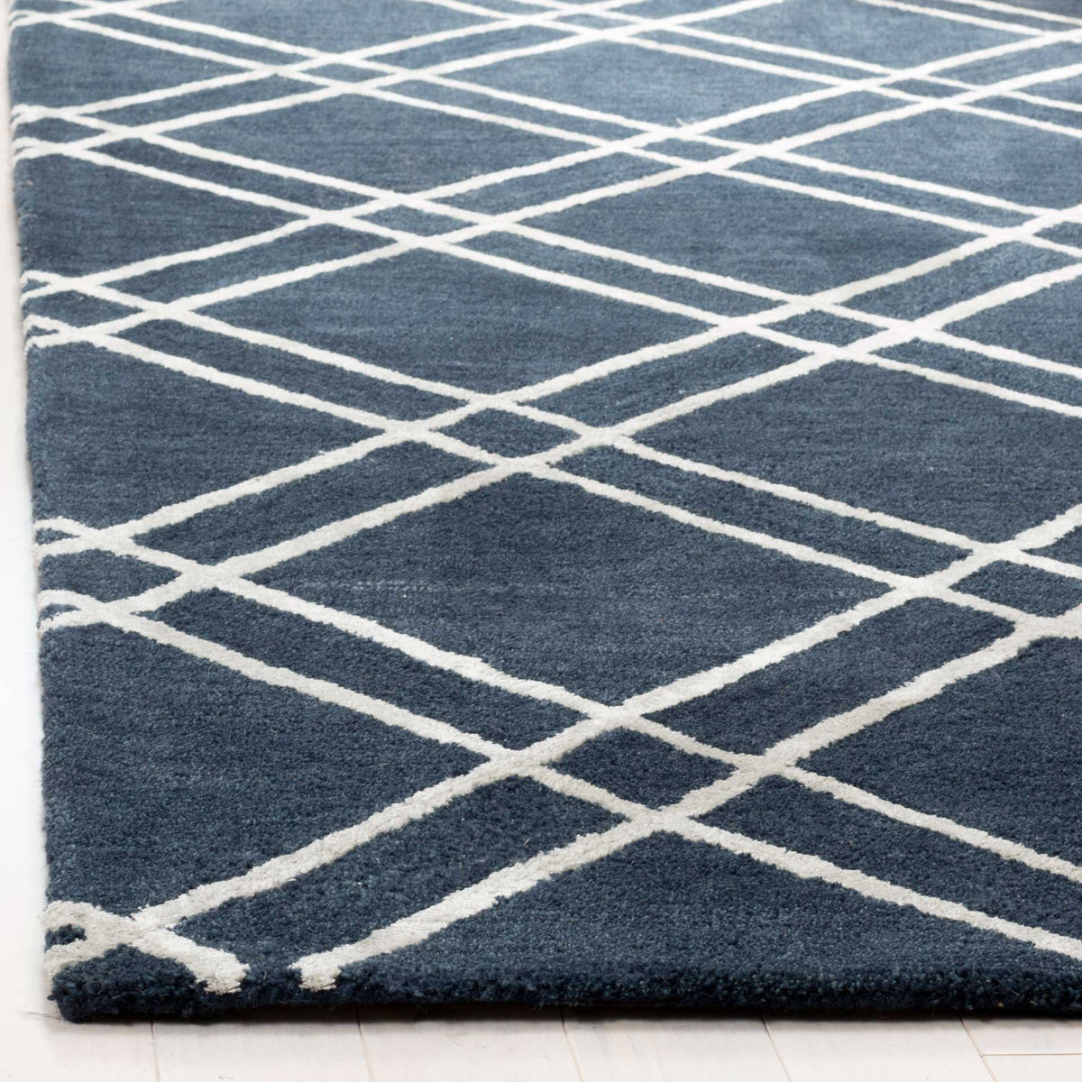 Plush navy wool and textured silver lines meet at a neatly finished edge