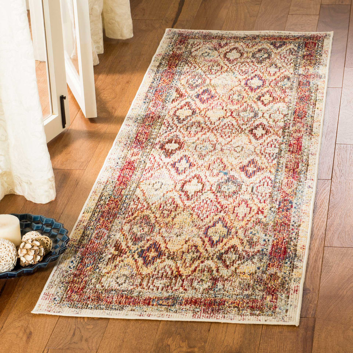 Rose and cream tones bring vintage charm to an intricate runner on warm wood floors.