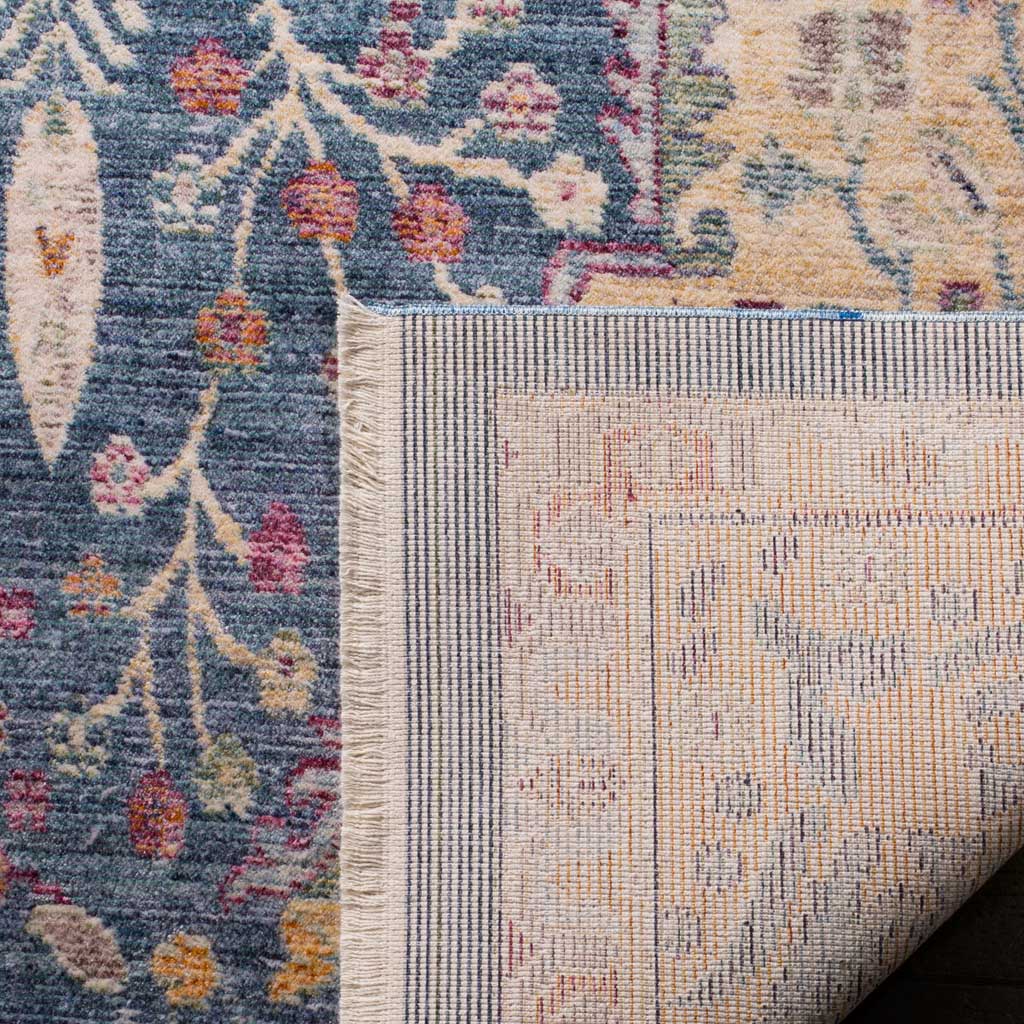 A folded corner reveals the rug's woven cotton backing beneath its colorful blue floral pile.