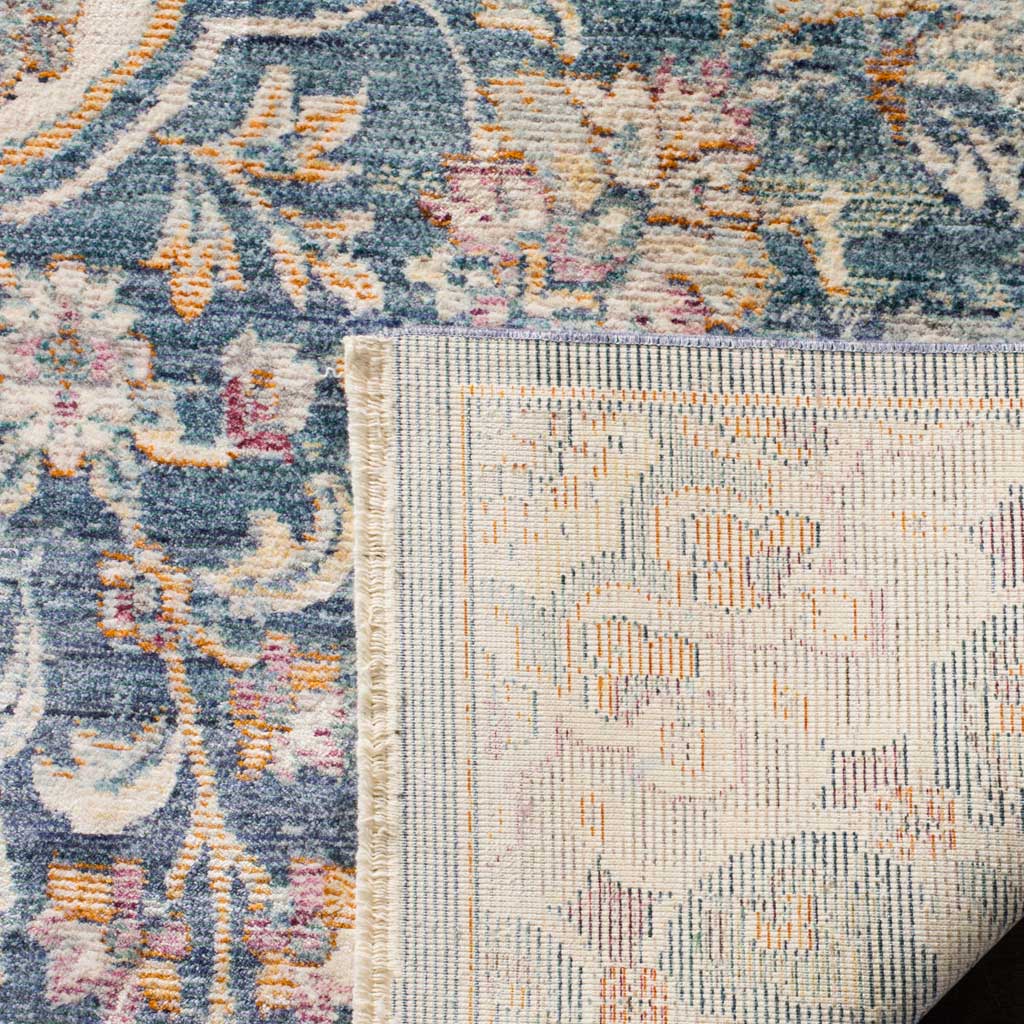A folded edge reveals the rug's woven cotton backing beneath its colorful floral surface.