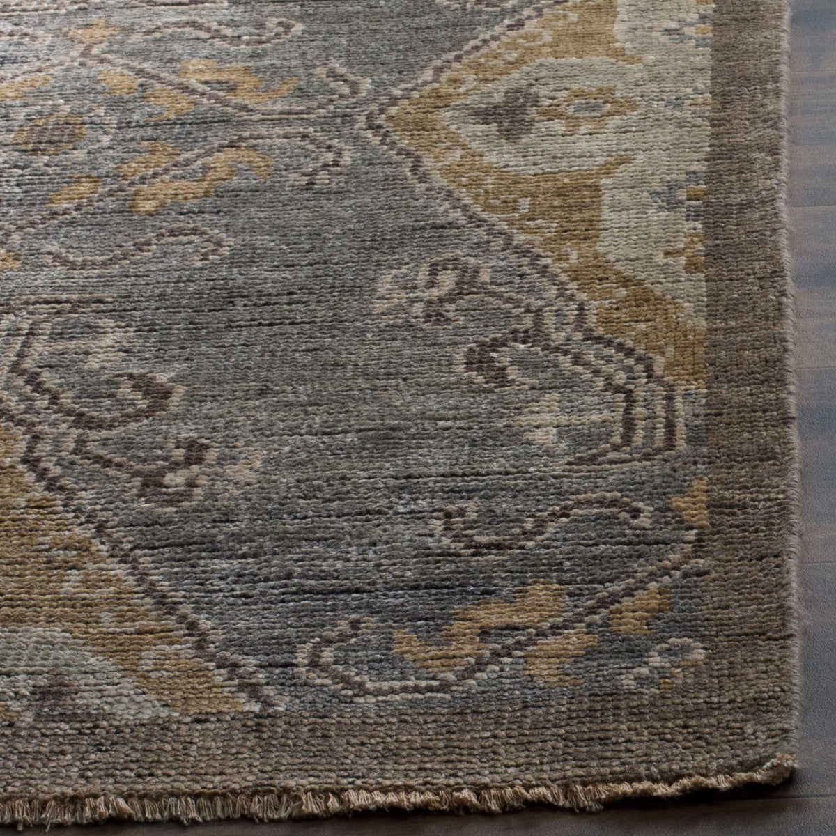 Short fringe and textured wool frame intricate charcoal and taupe motifs