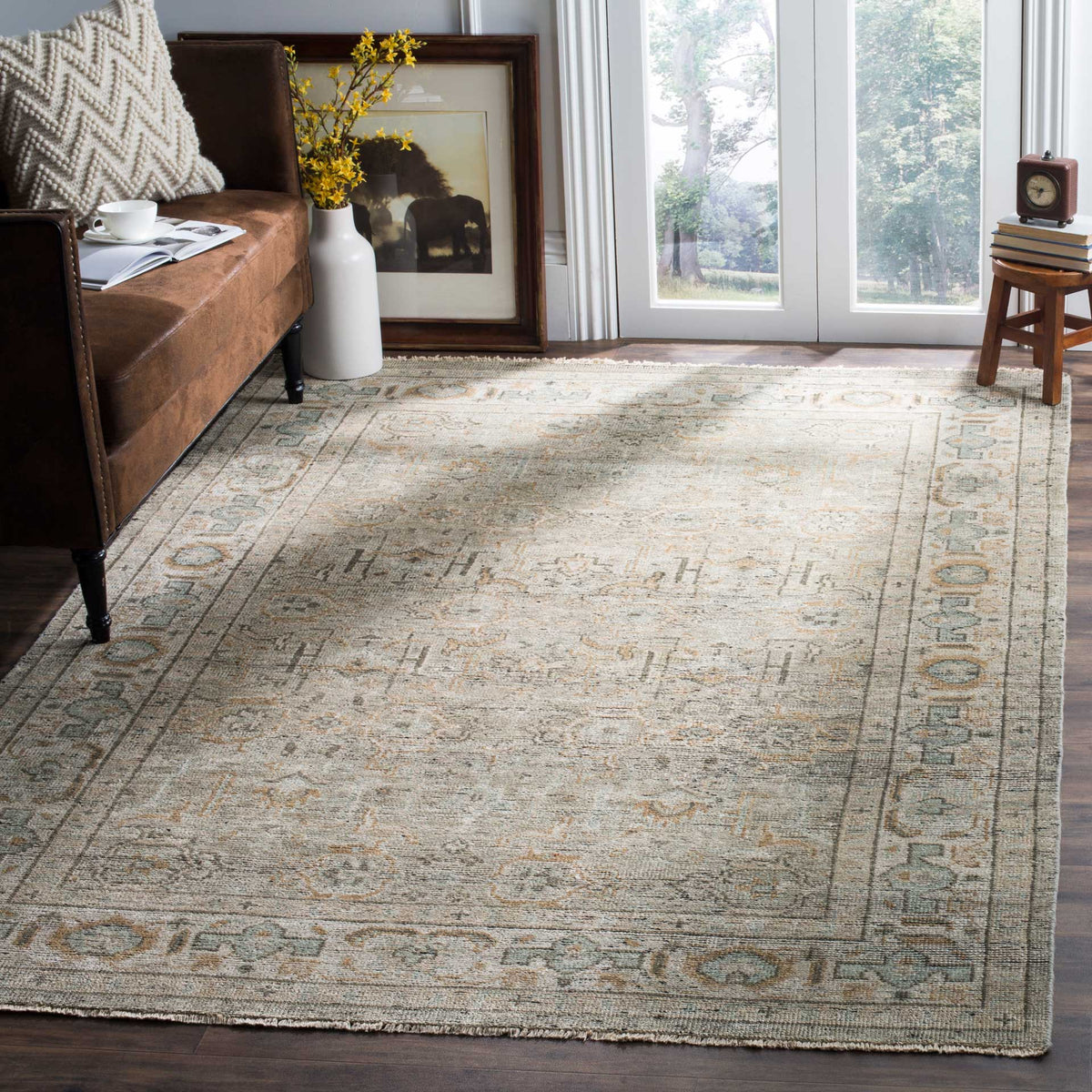 A linen and dusty teal rug adds a gently faded ornamental pattern to the living space