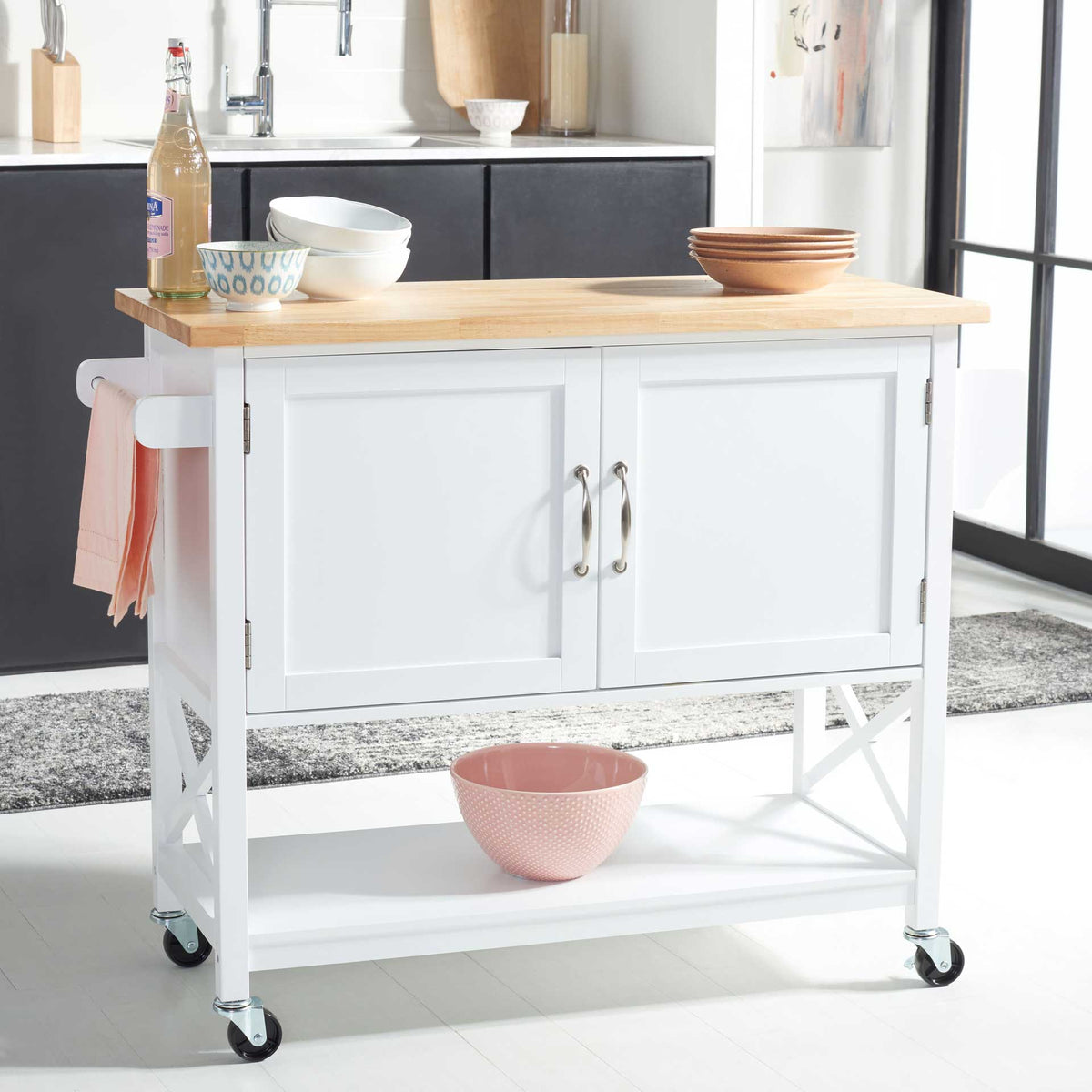 A natural wood countertop, towel bar, enclosed cabinet, and open shelf bring versatile storage to the kitchen