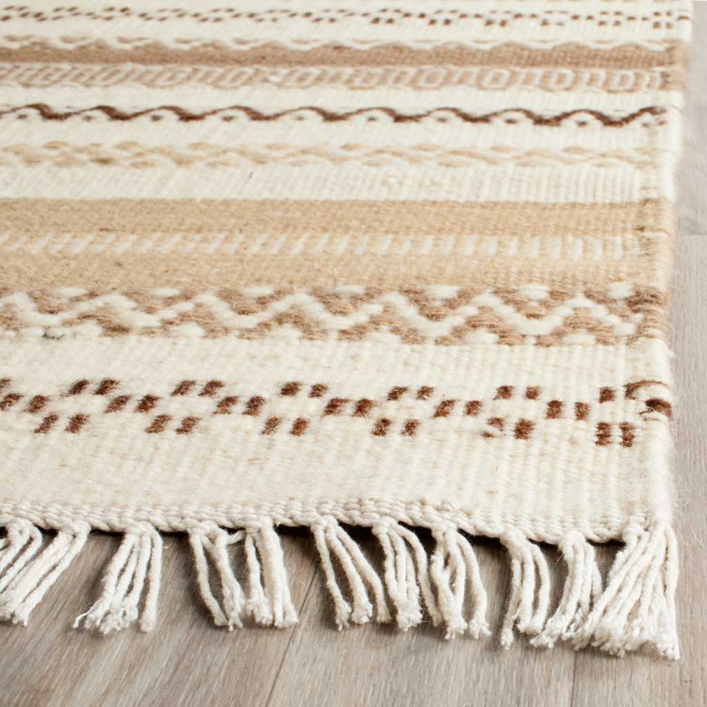 Cream fringe frames textured tan and brown motifs in this handwoven wool-cotton rug