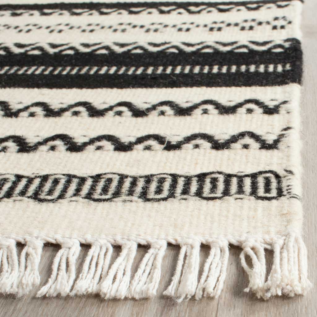 Ivory fringe and bold black zigzag motifs highlight the textured handwoven edge