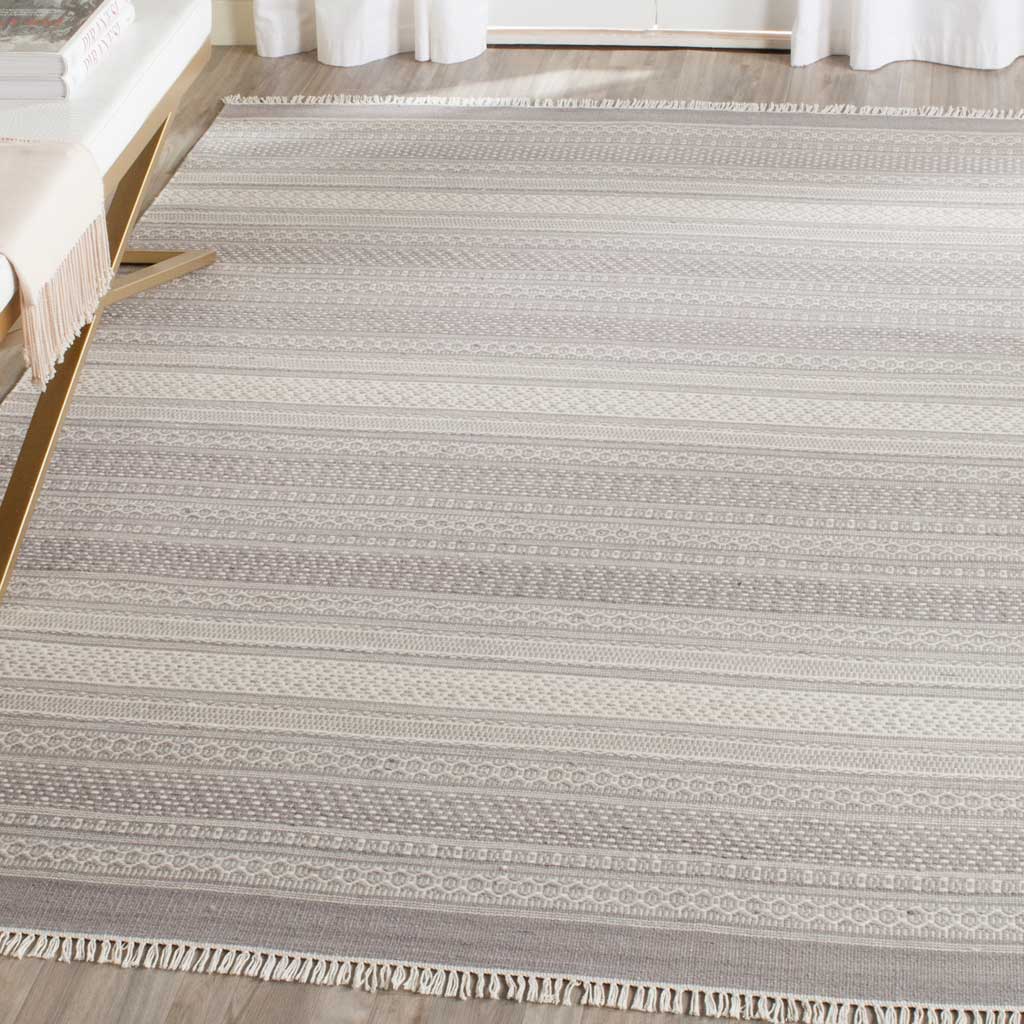 Muted gray stripes and ivory fringe create an inviting foundation for a bright interior.