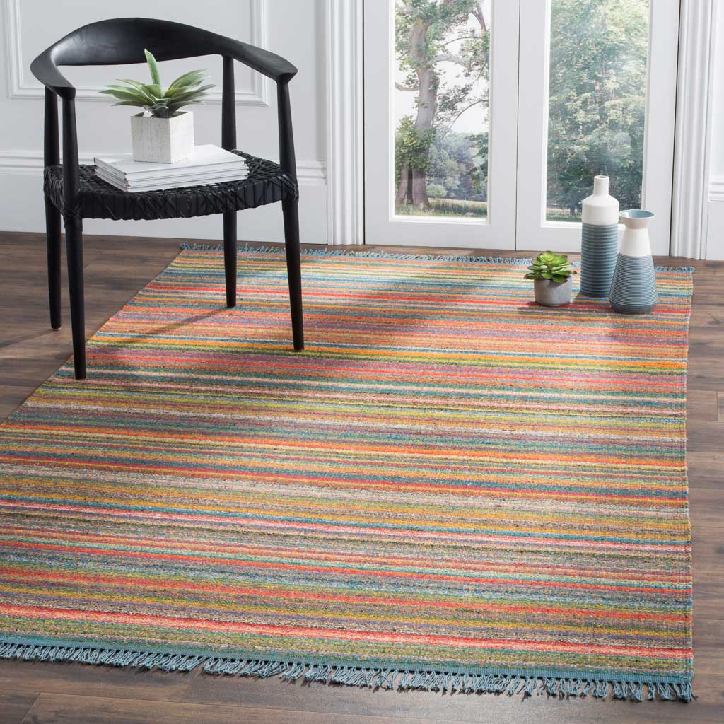 Colorful horizontal stripes create a lively foundation beneath a chair, with blue fringe at the ends