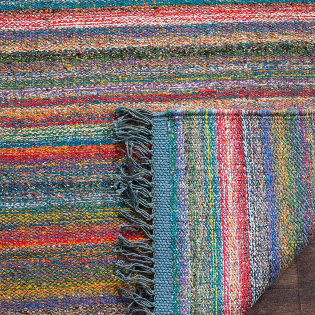 A folded edge reveals a tightly woven underside alongside vivid stripes and blue fringe