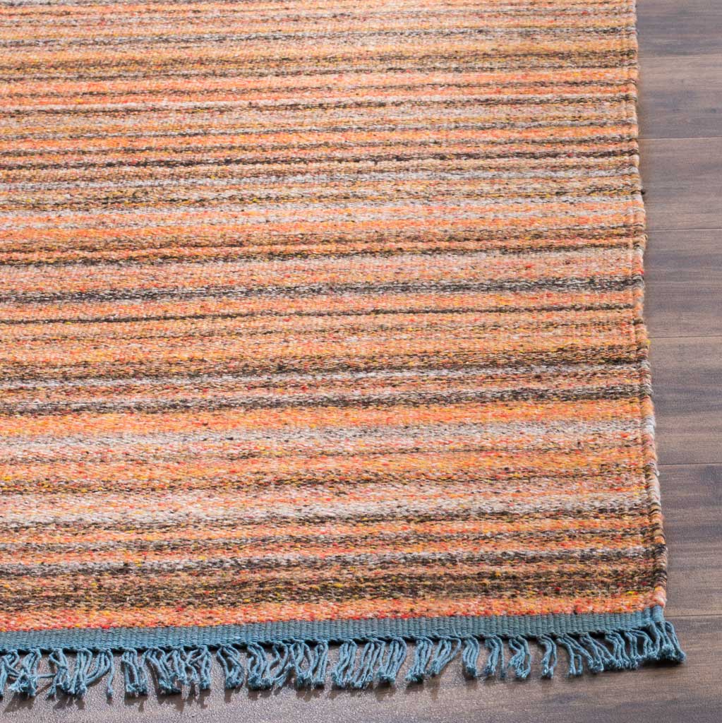 Blush and charcoal woven stripes meet a blue-trimmed edge and loosely twisted fringe