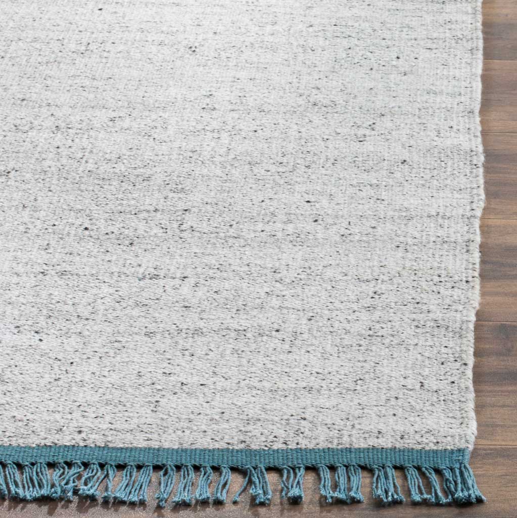 A teal band and knotted fringe accent the flecked gray and ivory weave