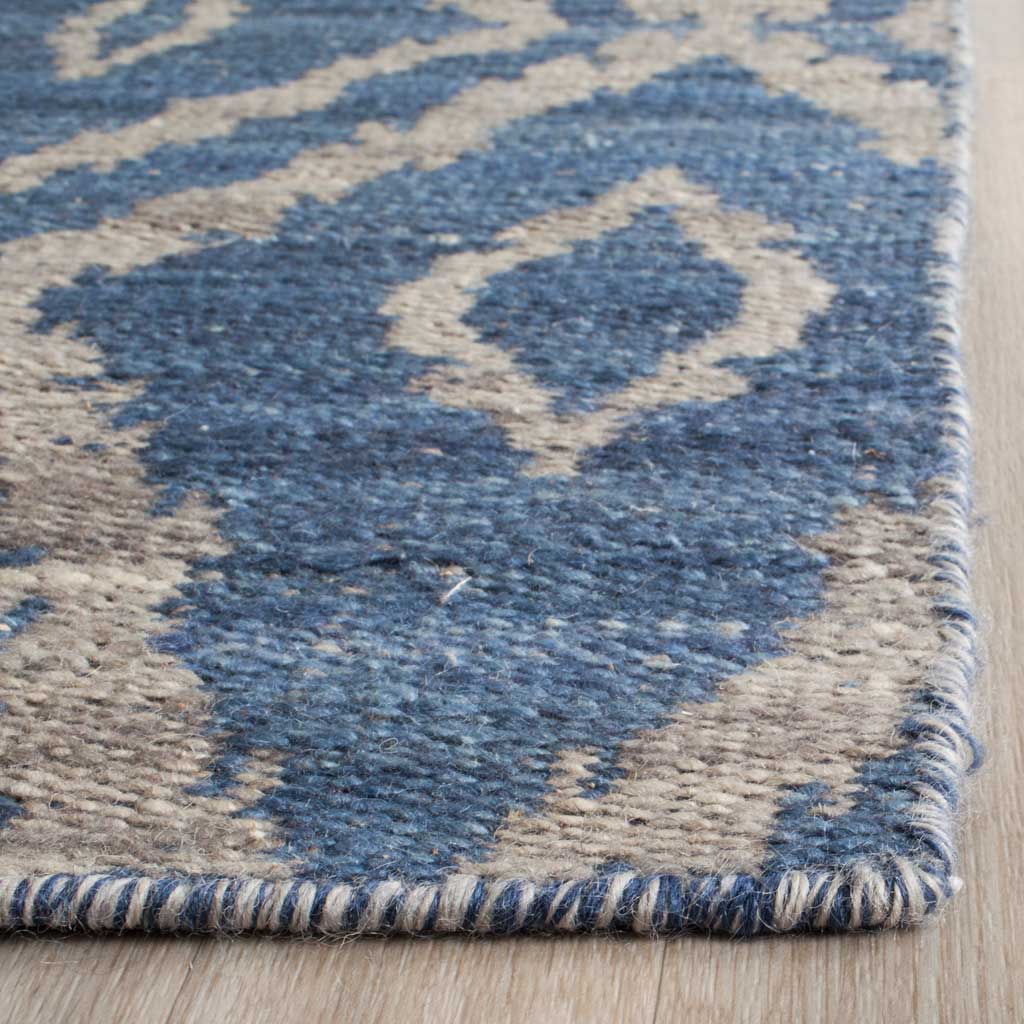 Blue wool and gray diamond motifs meet at a tightly bound rug edge.