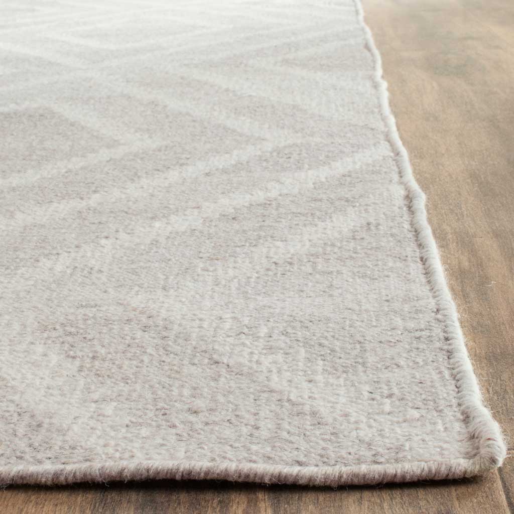 Soft ivory rug with subtle tonal texture and a neatly bound edge