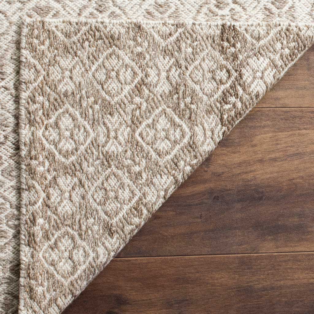 The woven reverse carries the rug's gray and ivory diamond pattern through its textured construction