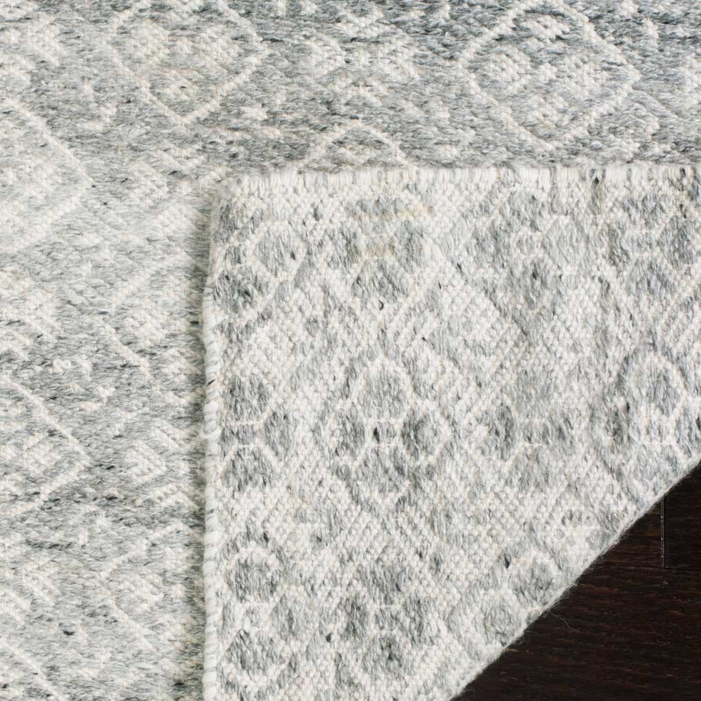 Muted silver motifs carry through the textured reverse of this ivory wool rug