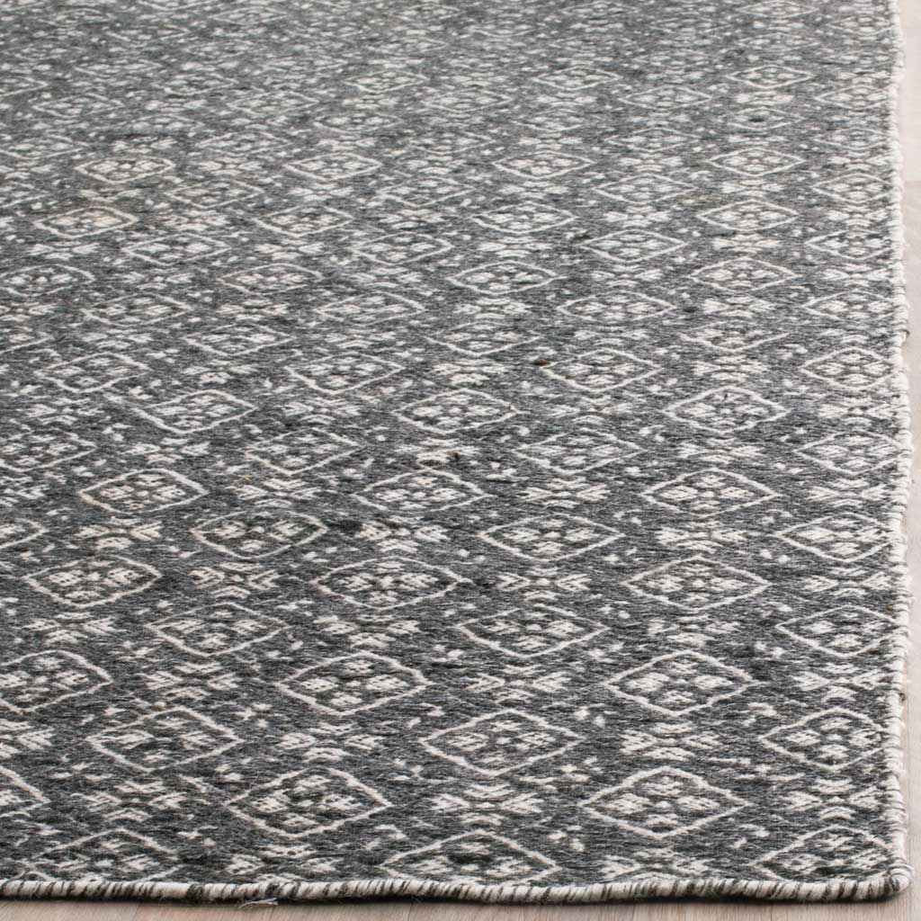 Ivory medallions and a neatly finished edge add definition to the textured charcoal wool