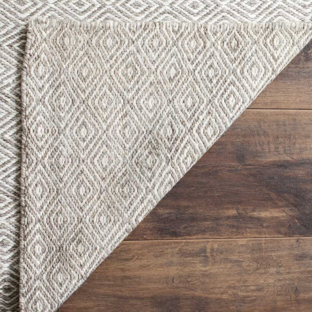 The woven reverse reveals a textured ivory and graphite diamond pattern