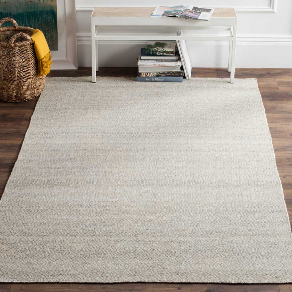 Soft ivory and silver tones lend this wool rug a calm, gently patterned finish