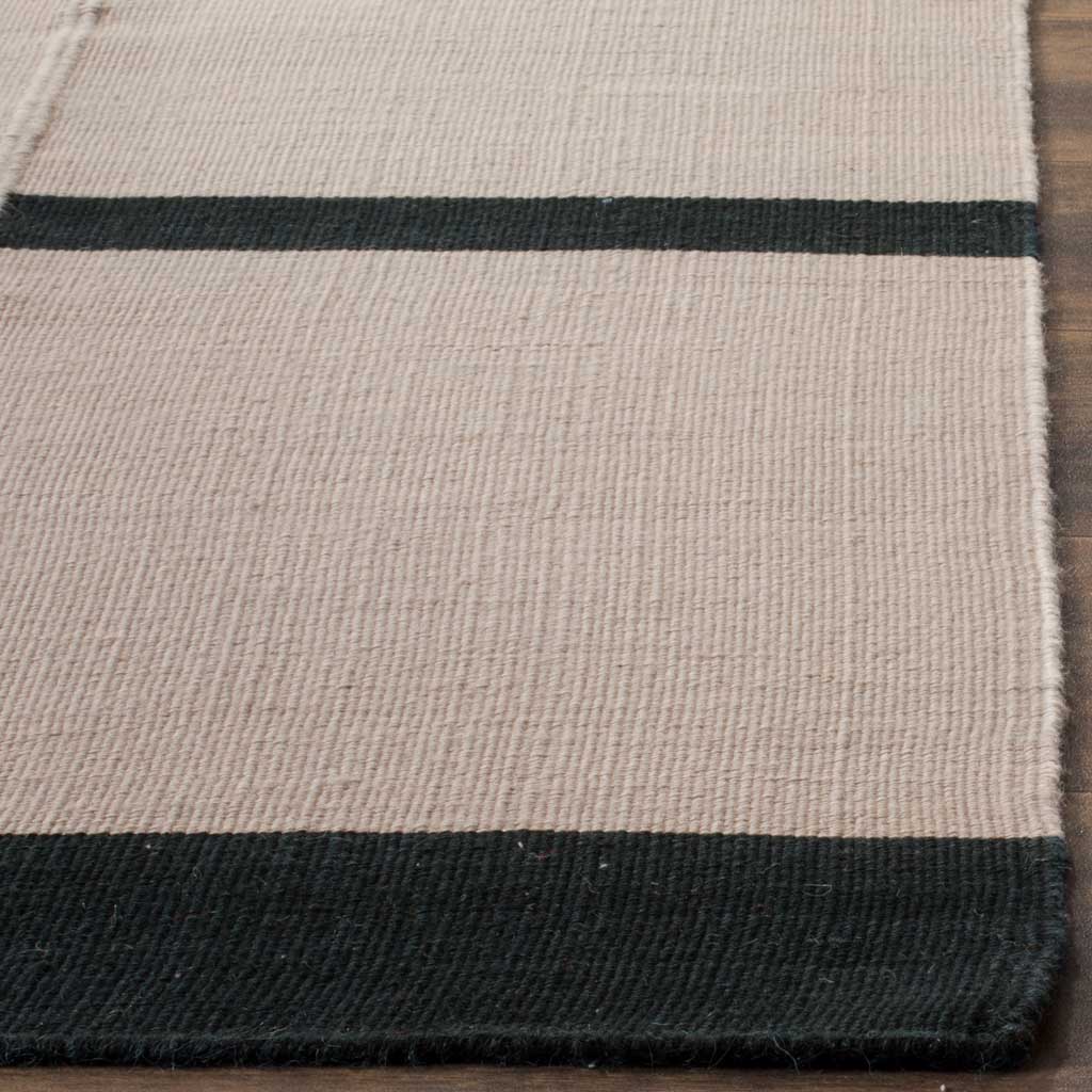 A broad black border anchors the rug's fine gray wool texture and crisp linear accents