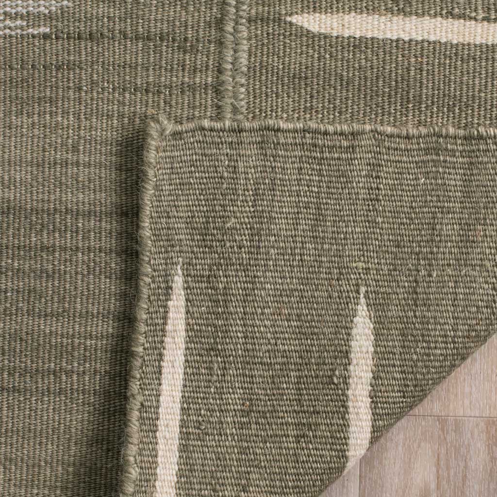 A folded edge reveals the rug's woven backing, ivory details and bound finish