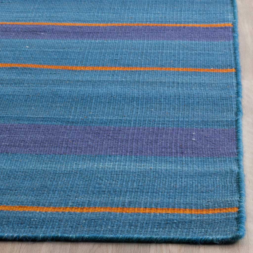 Finely woven blue and purple bands meet bright orange stripes along the rug's finished edge